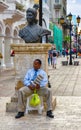 Santo Domingo, Dominican Republic. A man sitting at the base of Bartolomeo Colon statue, located in Conde street. b/n version