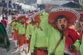 People greeting, using masks, disguised as mariachi with green shirts and orange hats
