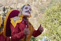 Person doing thumbs up, with mask with mustache, red dress and mexican