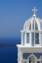 Santorini, Greece church tower with cross against blue water