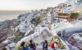 SANTORINI, GREECE - JULY 2014: Tourists enjoy classic greek city Royalty Free Stock Photo