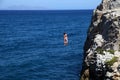 Girls jumping in water from a rock