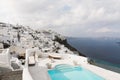 SANTORINI, GREECE - MAY 2018: View over Aegean sea, Firostefani village and volcano caldera with luxury hotel and infinity swimmin Royalty Free Stock Photo