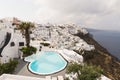 SANTORINI, GREECE - MAY 2018: View over Aegean sea, Firostefani village and volcano caldera with luxury hotel and infinity swimmin Royalty Free Stock Photo