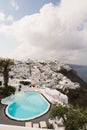 SANTORINI, GREECE - MAY 2018: View over Aegean sea, Firostefani village and volcano caldera with luxury hotel and infinity swimmin Royalty Free Stock Photo