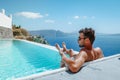 Santorini Greece Oia, young men in swim short relaxing in the pool looking out over the caldera of Santorini Island Royalty Free Stock Photo