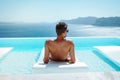 Santorini Greece Oia, young men in swim short relaxing in the pool looking out over the caldera of Santorini Island Royalty Free Stock Photo