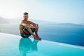 Santorini Greece Oia, young men in swim short relaxing in the pool looking out over the caldera of Santorini Island Royalty Free Stock Photo