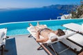 Santorini Greece Oia, young men in swim short relaxing in the pool looking out over the caldera of Santorini Island Royalty Free Stock Photo
