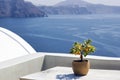 Santorini, Greece: A pot with flower or plant and a plate on a wooden table against beautiful sea ocean background Royalty Free Stock Photo