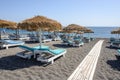 Sun loungers on the black volcanic sand beach of Perissa on the island of Santorini.