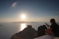 Santorini, Greece, September 21 2018, Tourist relax reading a book in the sunset