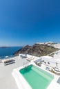 Santorini island Greece Beautiful vacation, chaise lounges on the terrace and amazing infinity pool with sea view. Luxury travel Royalty Free Stock Photo