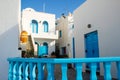 Fira town street with white houses and blue shutters. Cozy hotel building