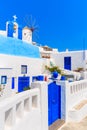 Typical Greek houses and windmill on street of Oia village, Santorini island, Greece Royalty Free Stock Photo