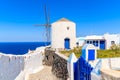 Typical white windmill on street of Oia village, Santorini island, Greece Royalty Free Stock Photo