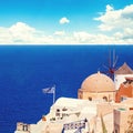 Santorini landscape with greek flag, white houses, sea and blue sky Royalty Free Stock Photo