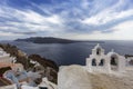 Santorini - Oia, view from the cliff to the caldera. White bell tower on the right and a white roof on the left on the cliff of Royalty Free Stock Photo