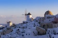 Santorini - Oia, view of white windmills on the slopes of the island. Around are white, picturesque houses between the stone