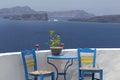 Santorini, a romantic seating area overlooking the Caldera, two blue chairs and a blue table by a white wall with a semicircular Royalty Free Stock Photo