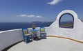Santorini, a romantic seating area overlooking the Caldera, two blue chairs and a blue table by a white wall with a semicircular Royalty Free Stock Photo