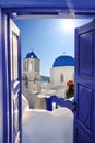 Santorini view with churches against blue door in Oia village, Greece Royalty Free Stock Photo