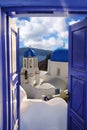 Santorini view with churches against old open blue door in Oia village, Greece Royalty Free Stock Photo