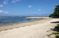 Sanur Beach in Bali, Indonesia with gazebo on stone breakwaters.