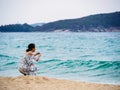 SANYA, HAINAN, CHINA - 4 MAR 2019 - Young Asian Chinese woman tourist snaps a photo at the beach with copy space Royalty Free Stock Photo