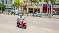 Sanya, Hainan, China - May 15, 2019: Road traffic. A woman rides an electromoped Royalty Free Stock Photo