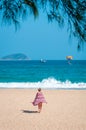 Sanya, Yalong Bay, Hainan, China - May 14, 2019: Beautiful clean beach. A young woman walks along the sandy seashore Royalty Free Stock Photo