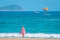 Sanya, Yalong Bay, Hainan, China - May 14, 2019: Beautiful clean beach. A young woman walks along the sandy seashore Royalty Free Stock Photo