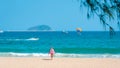 Sanya, Yalong Bay, Hainan, China - May 14, 2019: Beautiful clean beach. A young woman walks along the sandy seashore Royalty Free Stock Photo