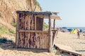 Sanzhejka, Ukraine, August 05, 2018: Old destroyed wooden building and trash on the sea beach. People resting near the garbage Royalty Free Stock Photo