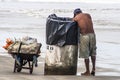 Man looks for aluminum cans for recycling in a trash bin