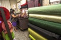 people inside of traditional fabric store with stacks of colorful textiles