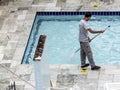 Worker man clean a swimming pool Royalty Free Stock Photo