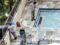 Worker man clean a swimming pool Royalty Free Stock Photo