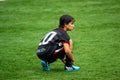 SAO PAULO, BRAZIL - SEPTEMBER 26, 2015: Young Boy tying boot on football field during rain