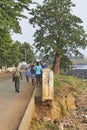 A Sao Tome Fishing Village Street Scene, with Women carrying Fish home, and People making their way to work.