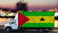 Sao Tome flag on the side of a white van against the backdrop of a blurred city and river. Logistics concept Royalty Free Stock Photo