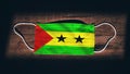 Sao Tome and Principe National Flag at medical, surgical, protection mask on black wooden background. Coronavirus CovidÃ¢â¬â19,