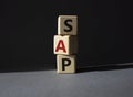 SAP - Systems Applications Products. Wooden cubes with word SAP. Beautiful grey background. Business and System Application