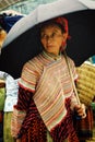 young flower hmong tribe member woman at the local farmer market high up in the mountains with an umbrella