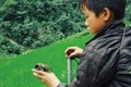 young boy with his injured small bird in front of rice fields