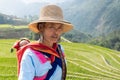 Sapa, Vietnam - May 2019: Hmong woman in traditional dress walks along rice terraces in Lao Cai province