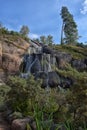 Sapokka Park in the city of Kotka in Finland. Waterfall with a cliff on the background of the lake, tourists on the bridge