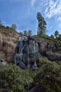 Sapokka Park in the city of Kotka in Finland. Waterfall with a cliff on the background of the lake, tourists on the bridge