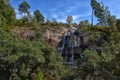 Sapokka Park in the city of Kotka in Finland. Waterfall with a cliff on the background of the lake, tourists on the bridge