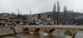Sarajevo, Bosnia and Herzegovina - March 8, 2020: Sheher bridge over the Milatsk river. Spring. Turbid water in the river and bare